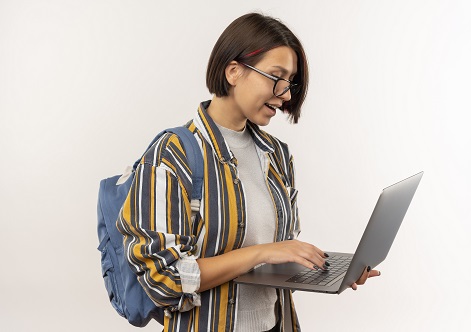 impressed young student girl wearing glasses and back bag using laptop isolated on white background